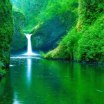 Peaceful scene of waterfall and lake.